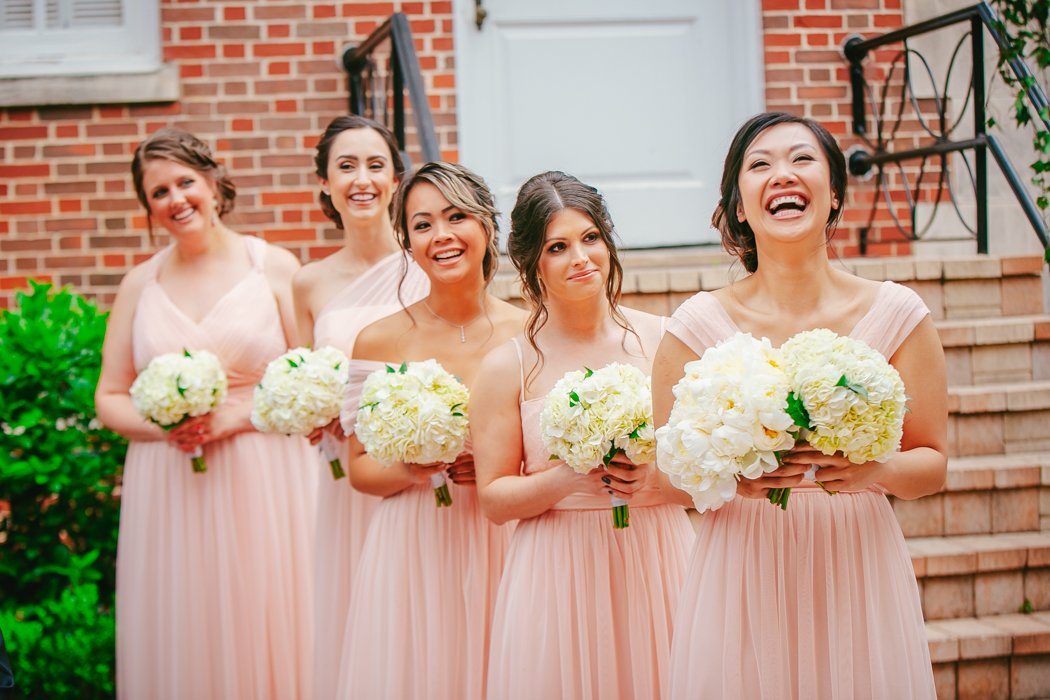 bridal party with pale pink dresses and white flowers