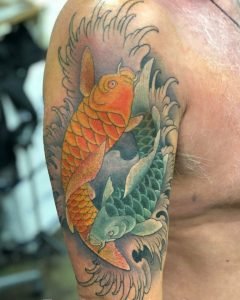 Koi cover-up on upper arm by Mikey Vigilante.
