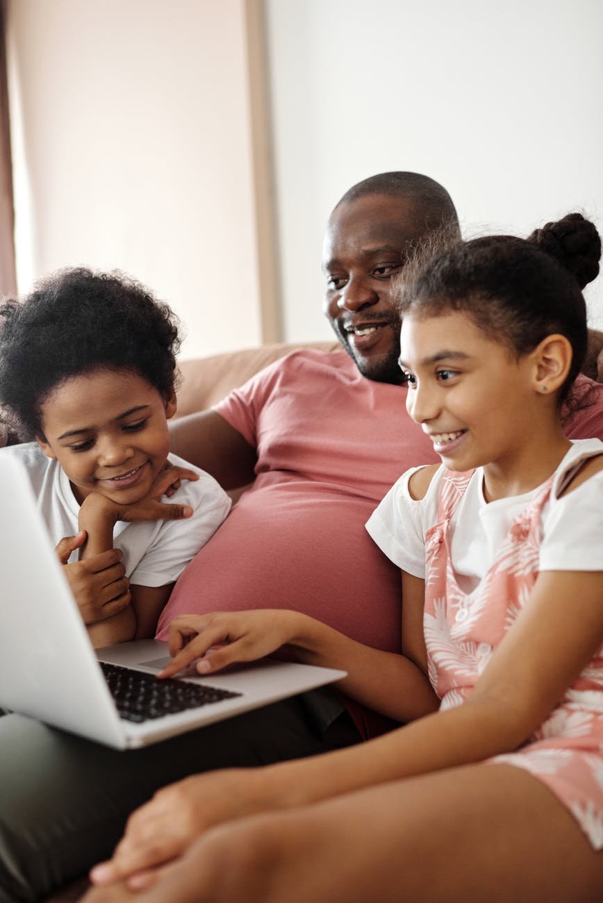 happy family sitting and looking at a laptop
