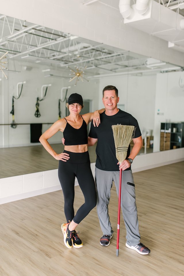 seersucker + mark morgan fitness by popular Indianapolis fitness blog, Seersucker and Saddles: image of a woman standing next to a man and resting her elbow on his shoulder inside a workout room.