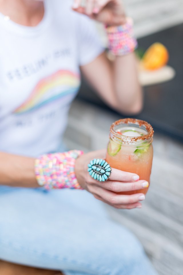 The Love of the Bowl by popular Indianapolis lifestyle blog, Seersucker and Saddles: image of a woman holding a spicy Paloma drink in a mason jar.
