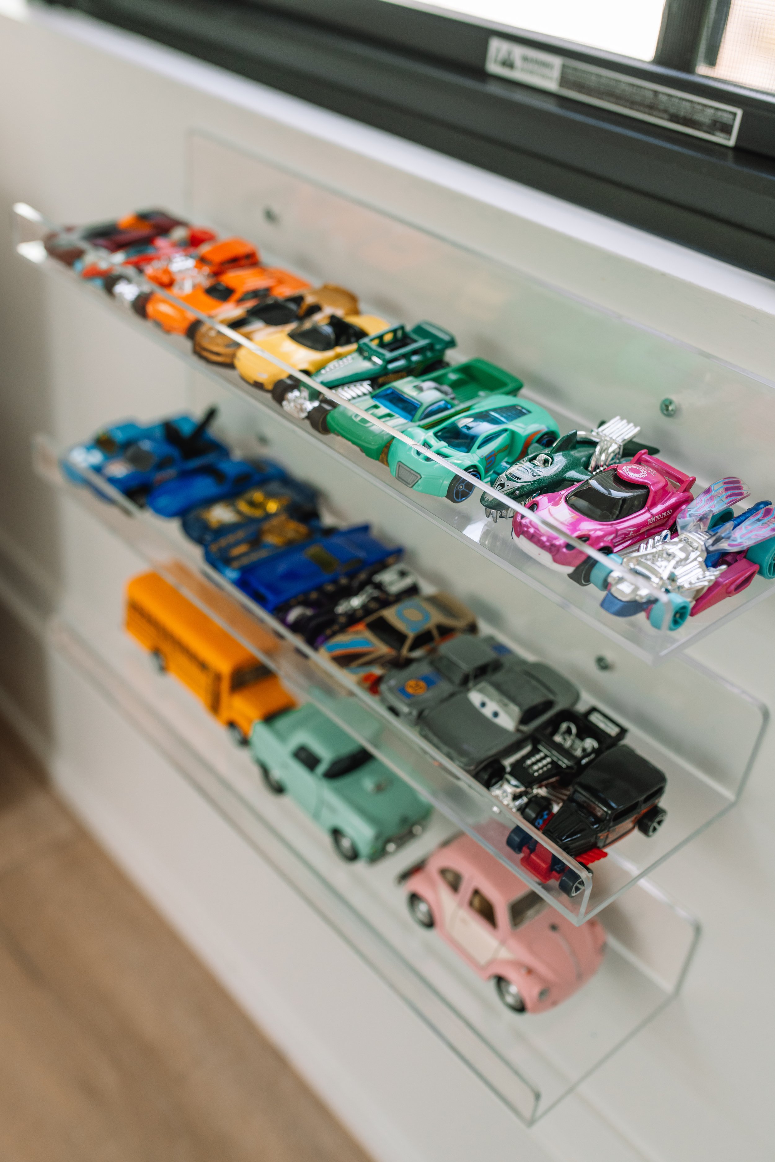 Walmart Kids by popular Indianapolis life and style blog, Seersucker and Saddles: image of a loft space decorated with Walmart VIVO Dual Acrylic 24" Floating Bookshelves filled with toy cars. 