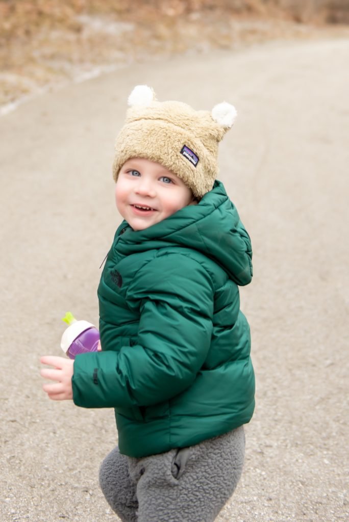 Backcountry Outdoor Gear by popular life and style blog, Seersucker and Saddles: image of a toddler boy wearing a Backcountry North Face Moondoggy Hooded Down Jacket and Backcountry Patagonia Baby Furry Friends Hat.