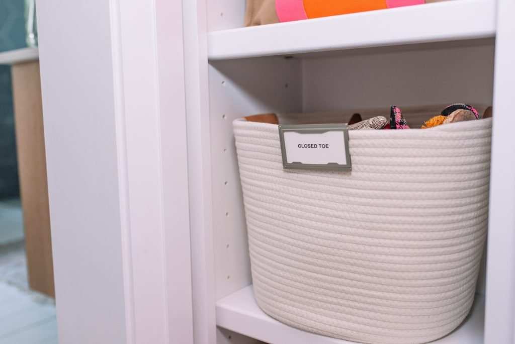 Closet Layout by popular Indianapolis life and style blog, Seersucker and Saddles: image of labeled rope bins on white shelving in a walk-in closet. 