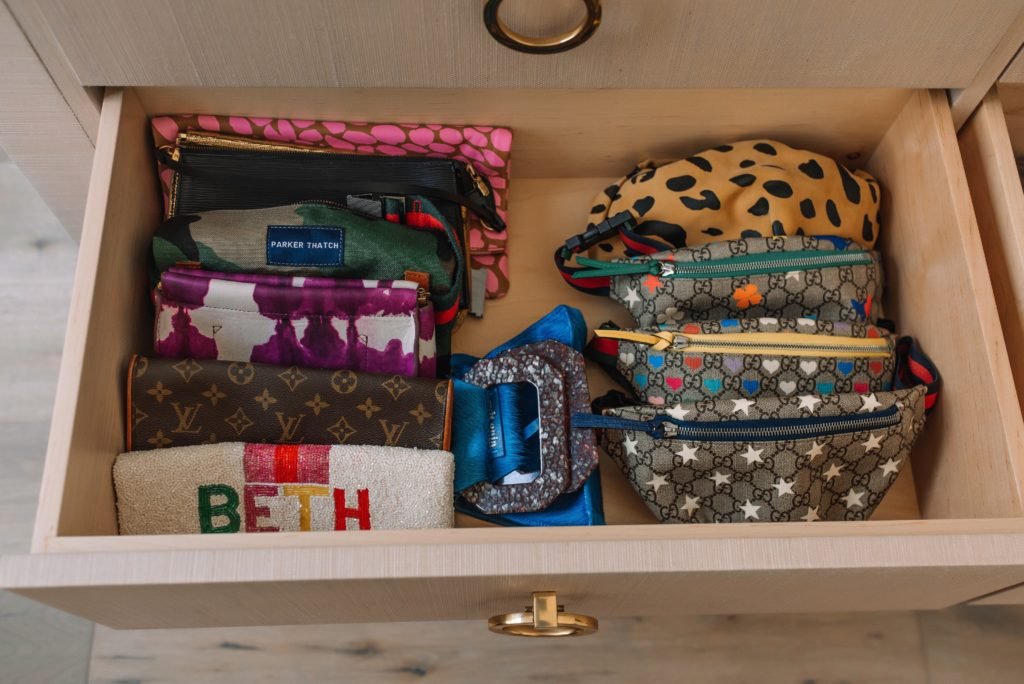 Closet Layout by popular Indianapolis life and style blog, Seersucker and Saddles: image of a opened drawer filled with various clutches and belt bags. 