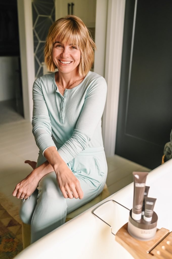 Colleen Rothschild BOGO by popular Indianapolis beauty blog, Seersucker and Saddles: image of a woman wearing a light blue loungewear set and sitting next to some Colleen Rothschild products. 