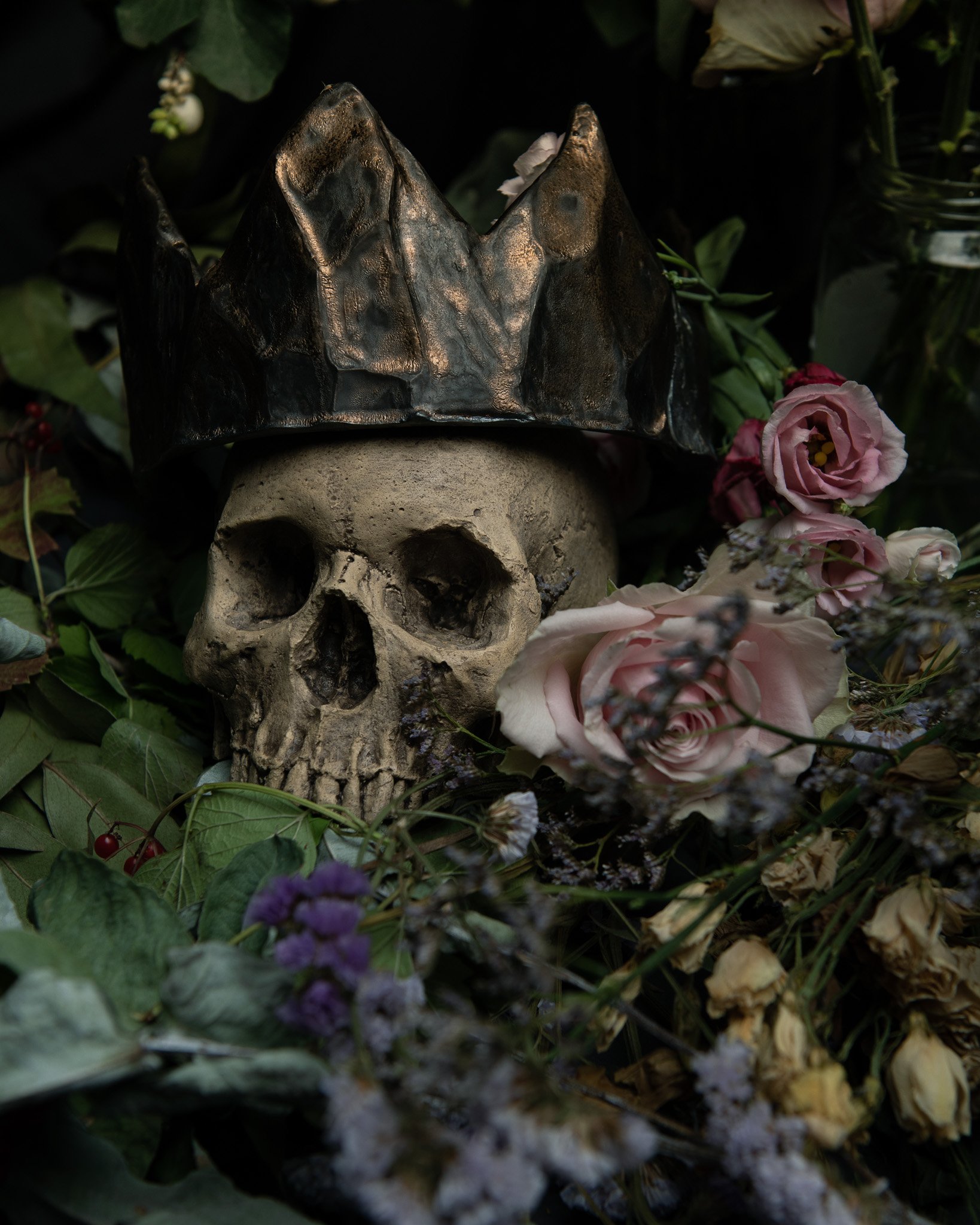 Arrangement of flowers, crown and skull