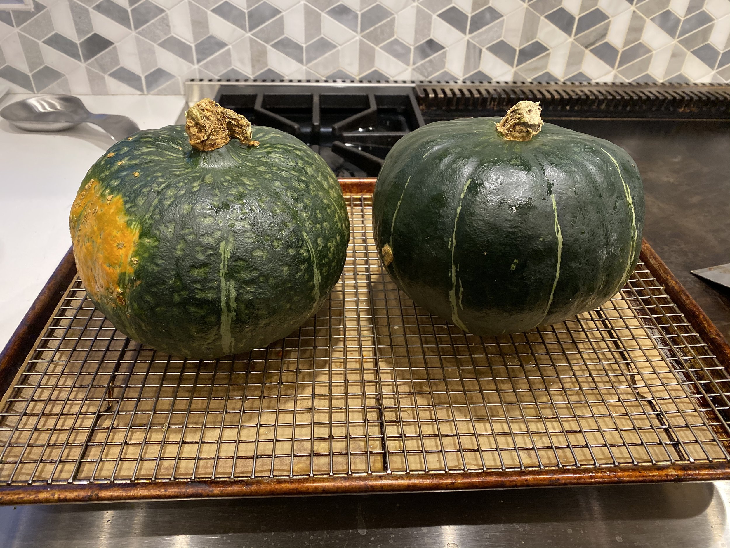 The kabocha (left) is rougher in texture and rounder in shape than the boxier buttercup (right).