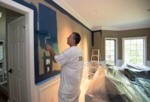 A professional painter applying a new paint color to a wall