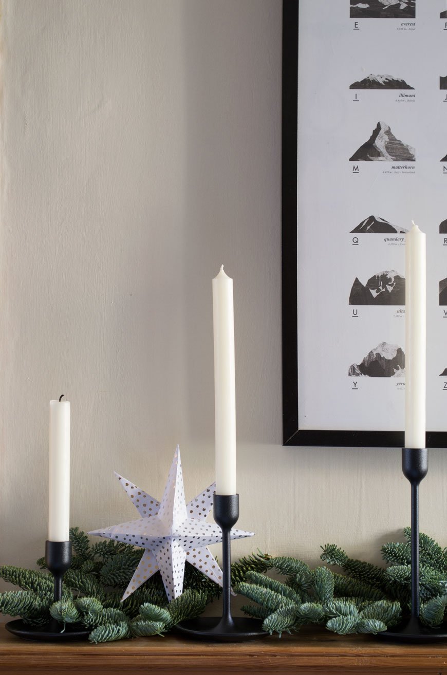 Edwardian mantlepiece styled with three black candlestick, sharing simple Nordic Christmas styling ideas. 