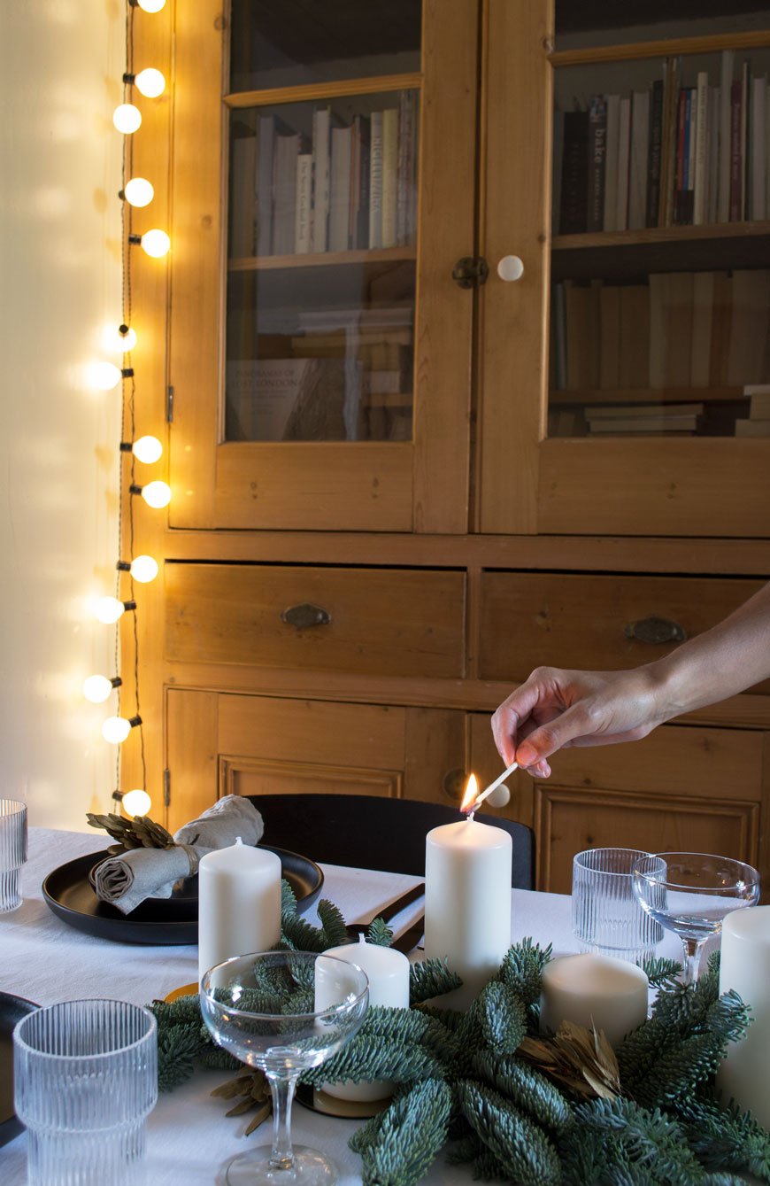 Lighting candles on the table I styled in our dining room to share our Nordic Christmas decorations and styling