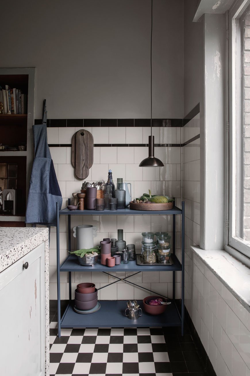Deep blue open shelves in a moody kitchen, designed by Ferm Living. 