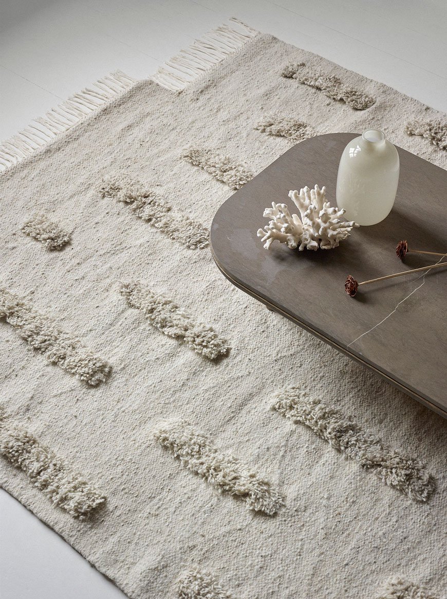 A tonal white tufted wool rug minimally styled, designed by Sera Helsinki.