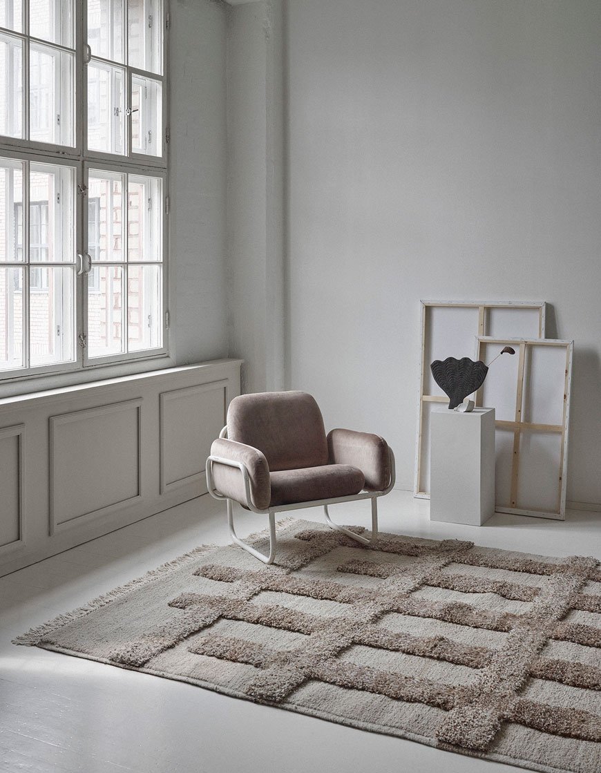 Handwoven knotted wool rug in brown and natural white, designed by Sera Helsinki. 