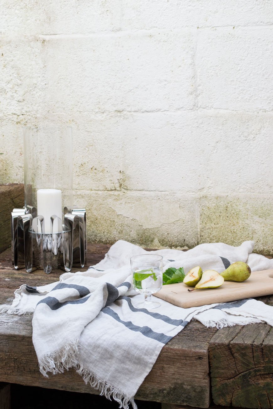 Still life with pears and a linen towel styled with the Frequency collection Hurricane lantern.