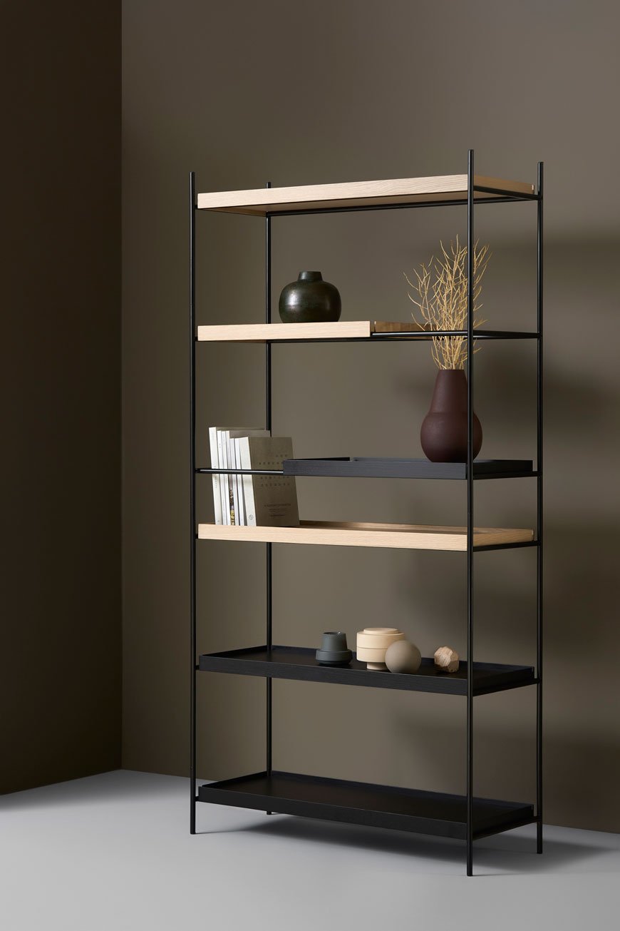 Sleek and slender Tray Shelf in black and natural oak in a minimalist setting, designed by Woud. 