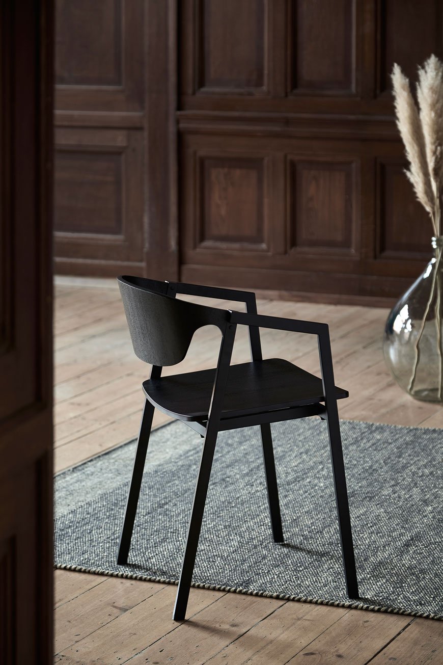 Woud design's latest Nordic dining chair in a minimalist setting with pampas grasses in a vase. 