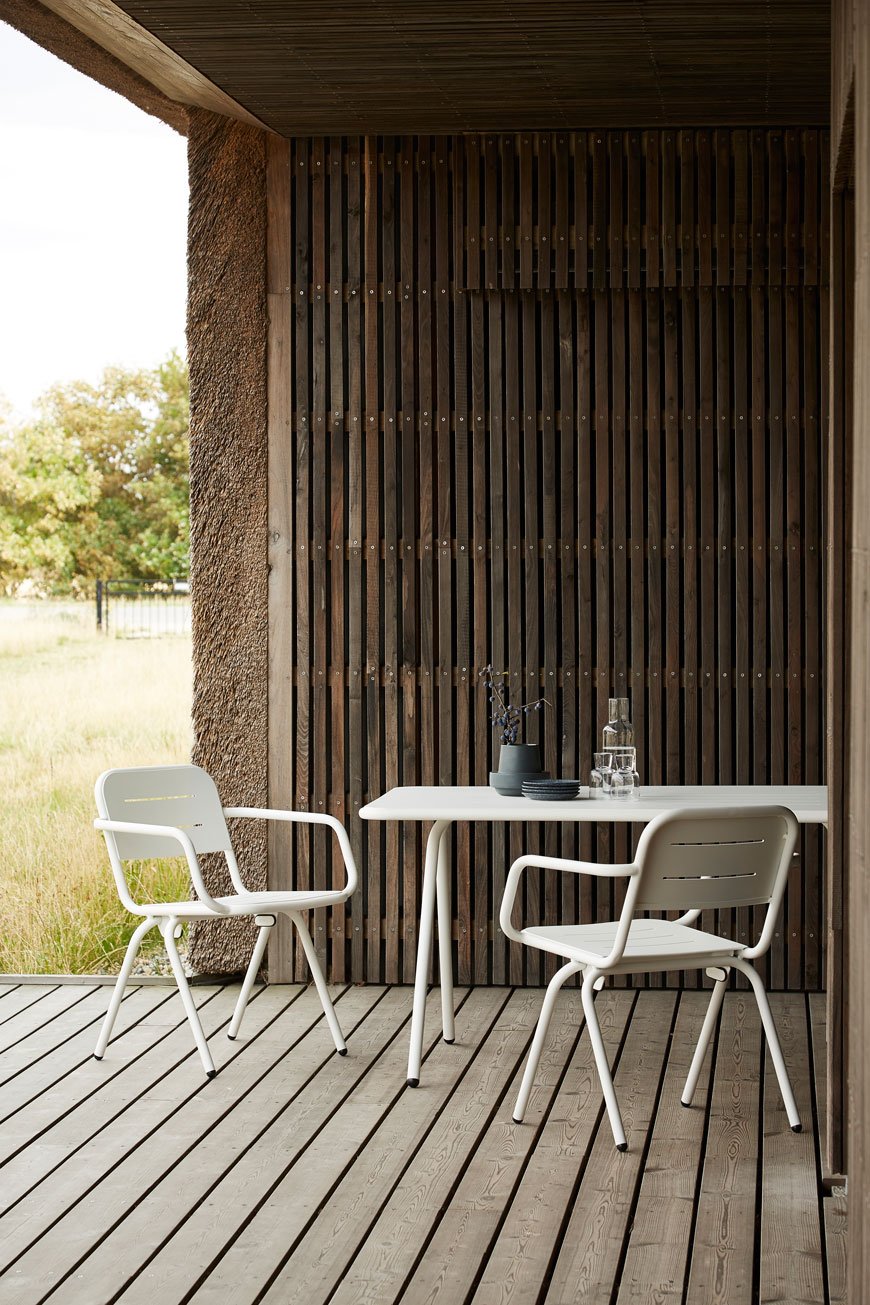 white metal bistro style outdoor furniture in a contemporary garden with decking. 