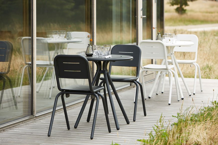 Monochrome outdoor furniture with curved metal frames, designed by Woud. 