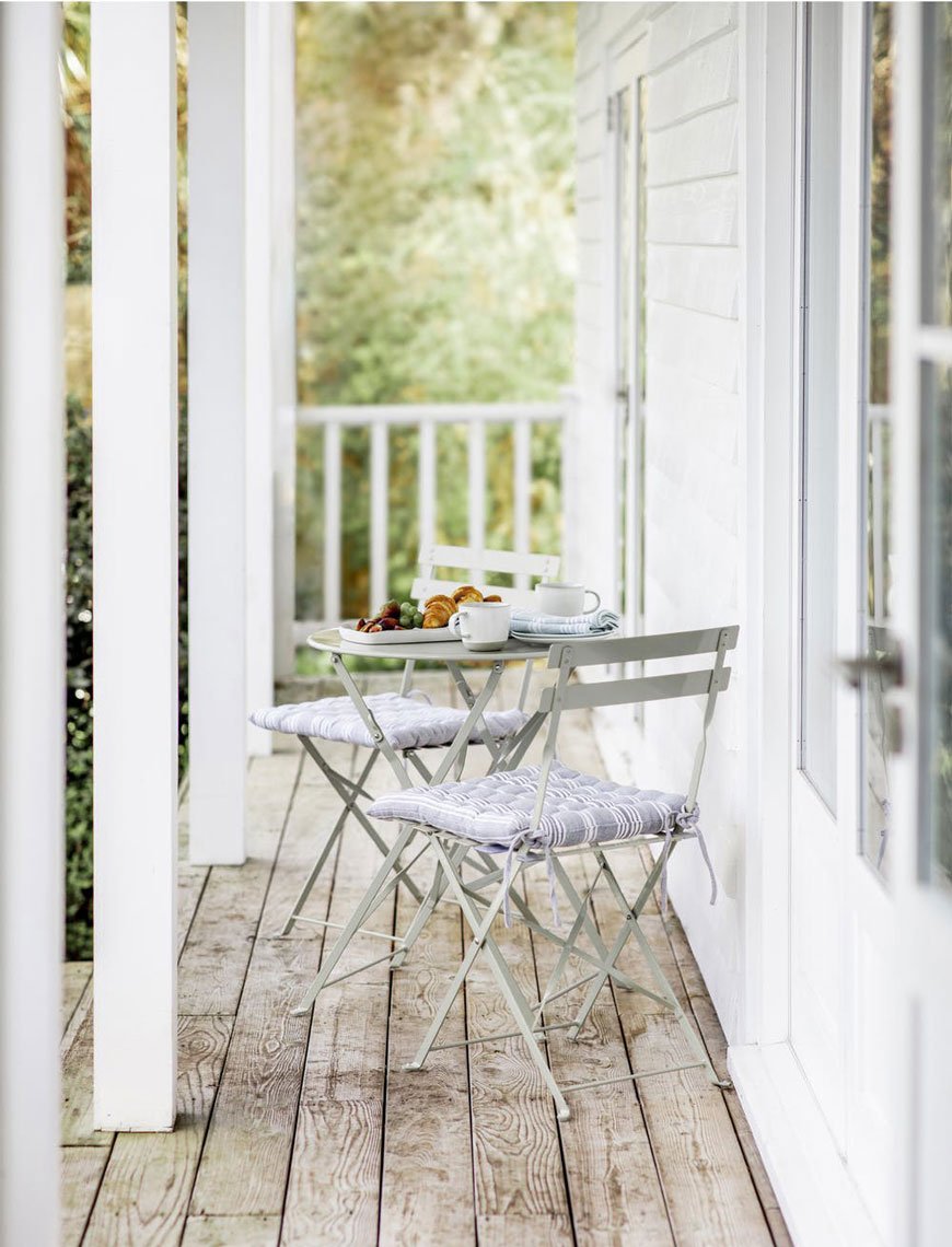 Classic bistro style outdoor furniture styled on a wooden veranda from Garden Trading, 