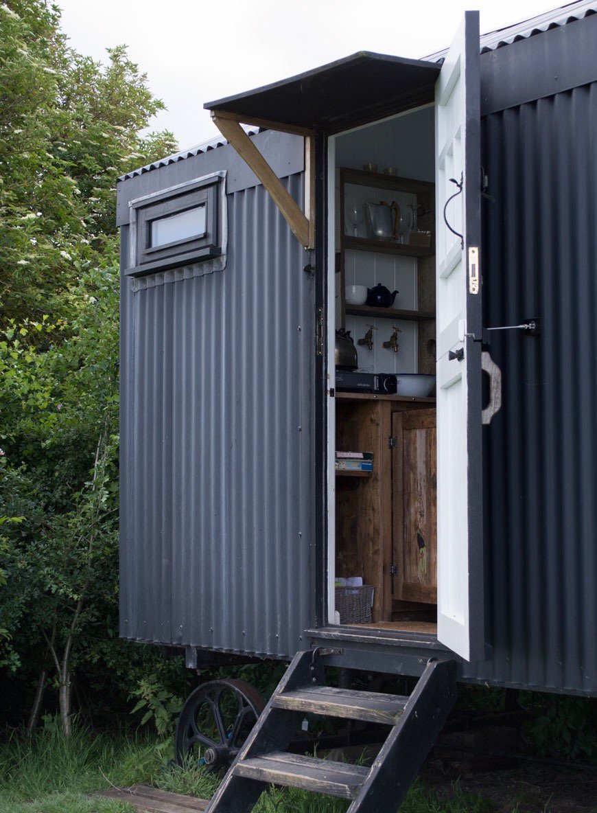 Modern rustic black shepherd's hut on a cozy stay at Elmley Nature Reserve. 