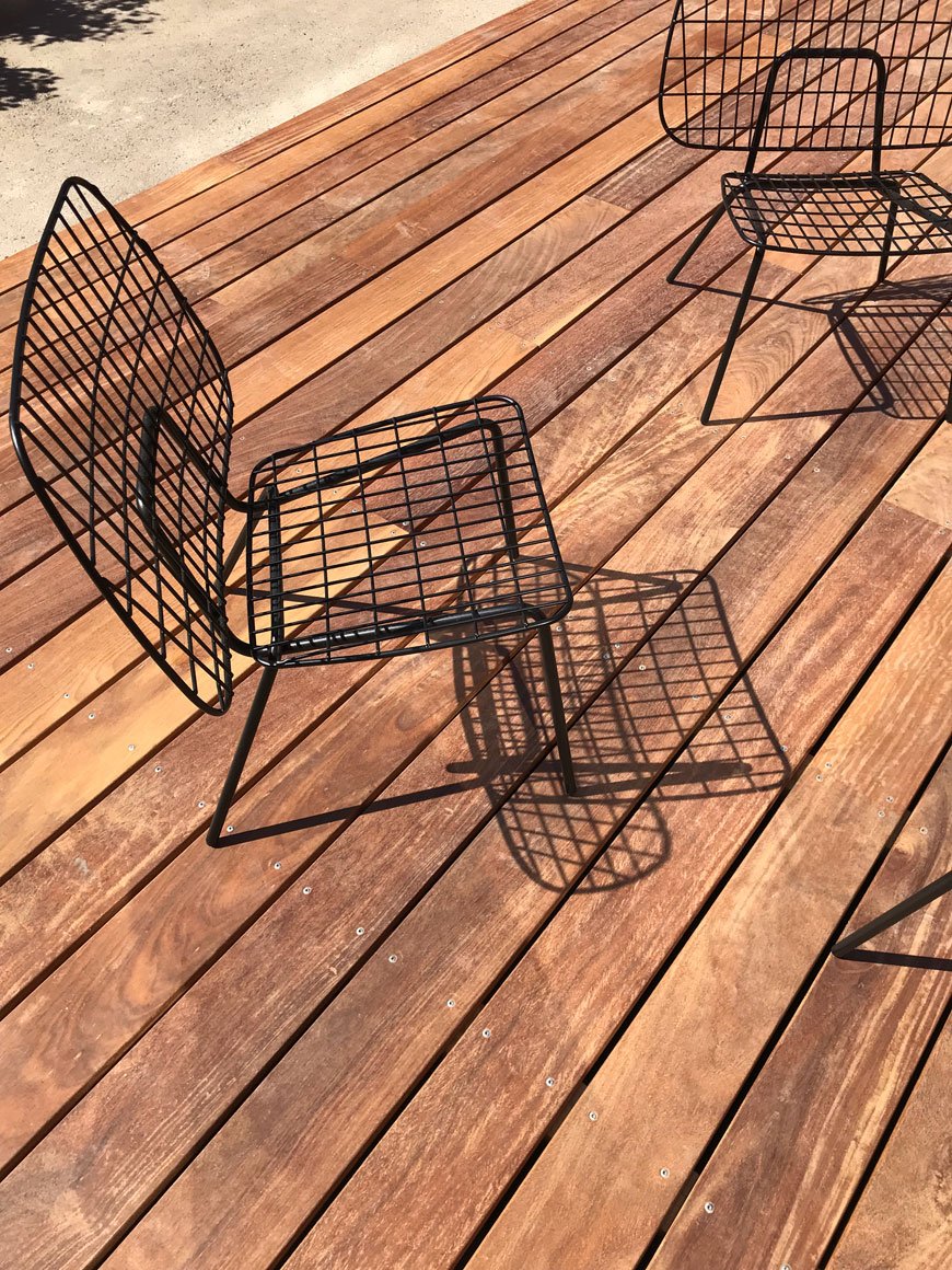 WM String Lounge Chairs sit on an outdoor wooden deck at The Audo hotel in Copenhagen. 