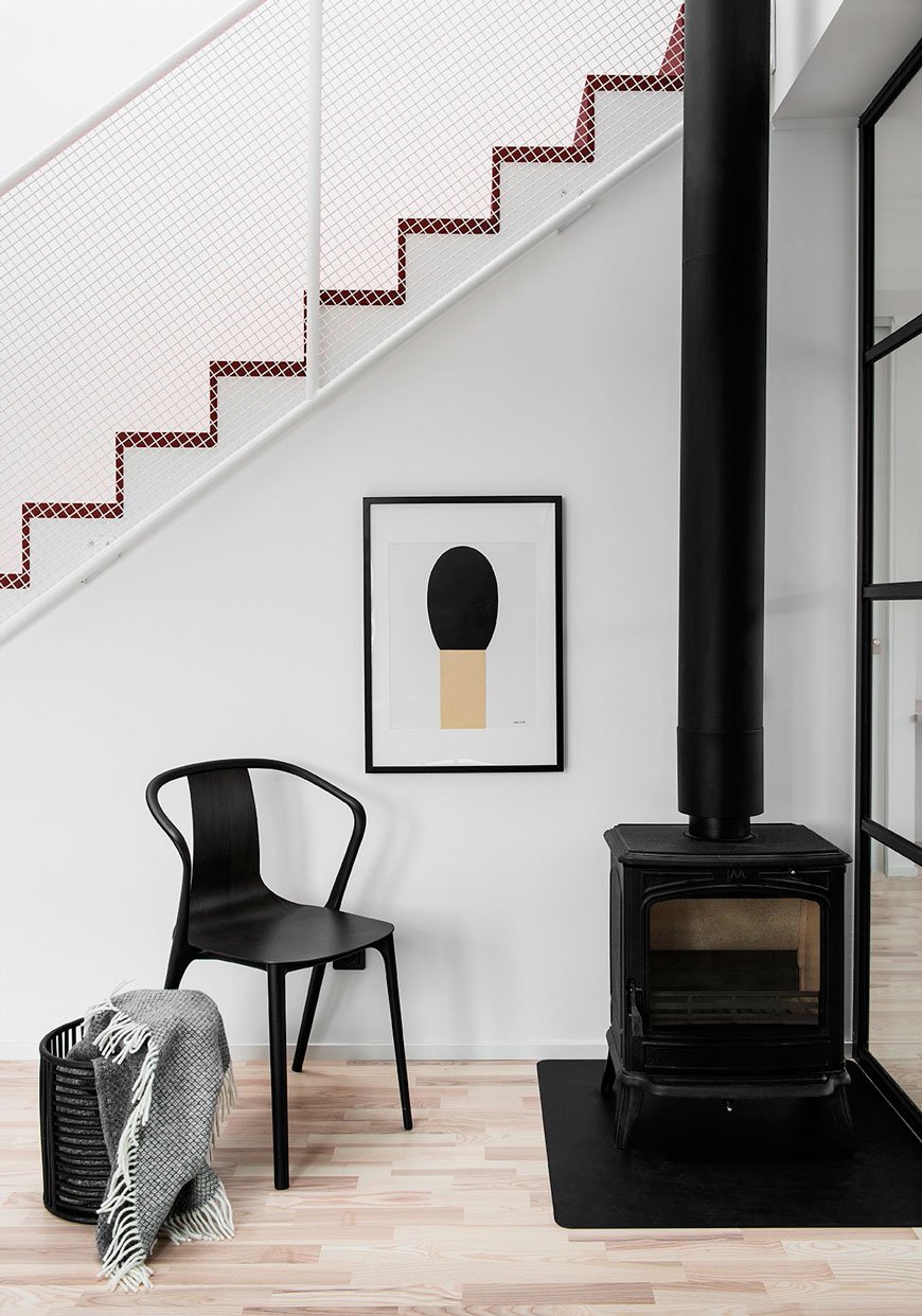 Architectural details show the minimal corrugated staircase and black wood burner, designed by Blooc. 