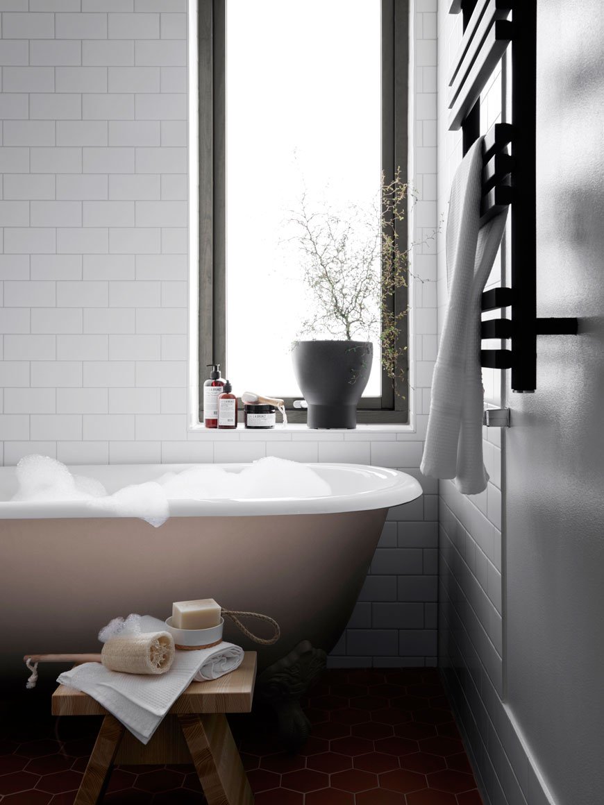A freestanding roll top bath filled with bubbles waits in the bathroom of a Parkhusen home, designed by Blooc. 