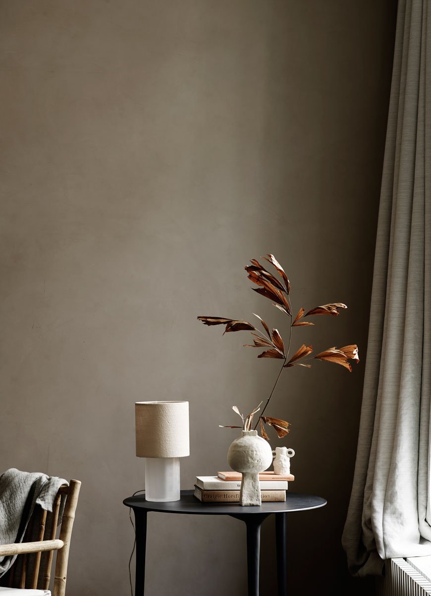 A simple black side table styled with autumnal leaves for Tine K Home's Autumn-Winter collection. 