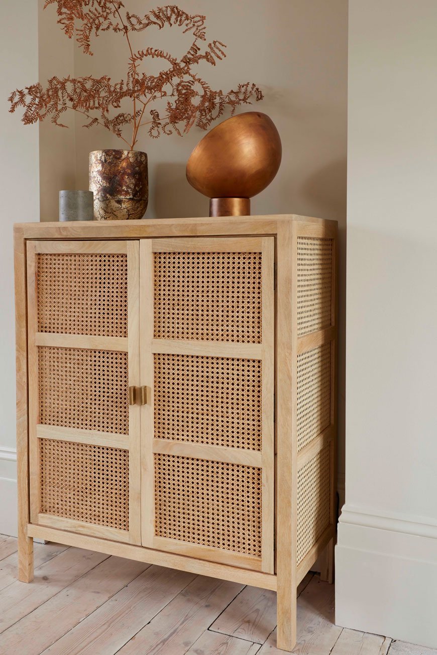 A French cane cabinet looks striking with a brass lamp on top for French Connection's Autumn-Winter collection. 