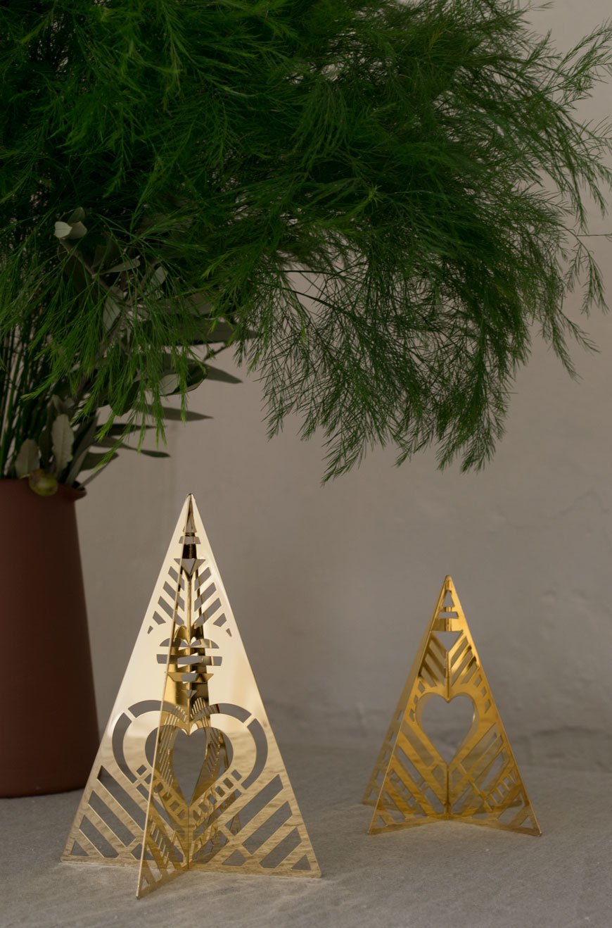 Gold plated Christmas tree ornaments on a natural linen table cloth. 