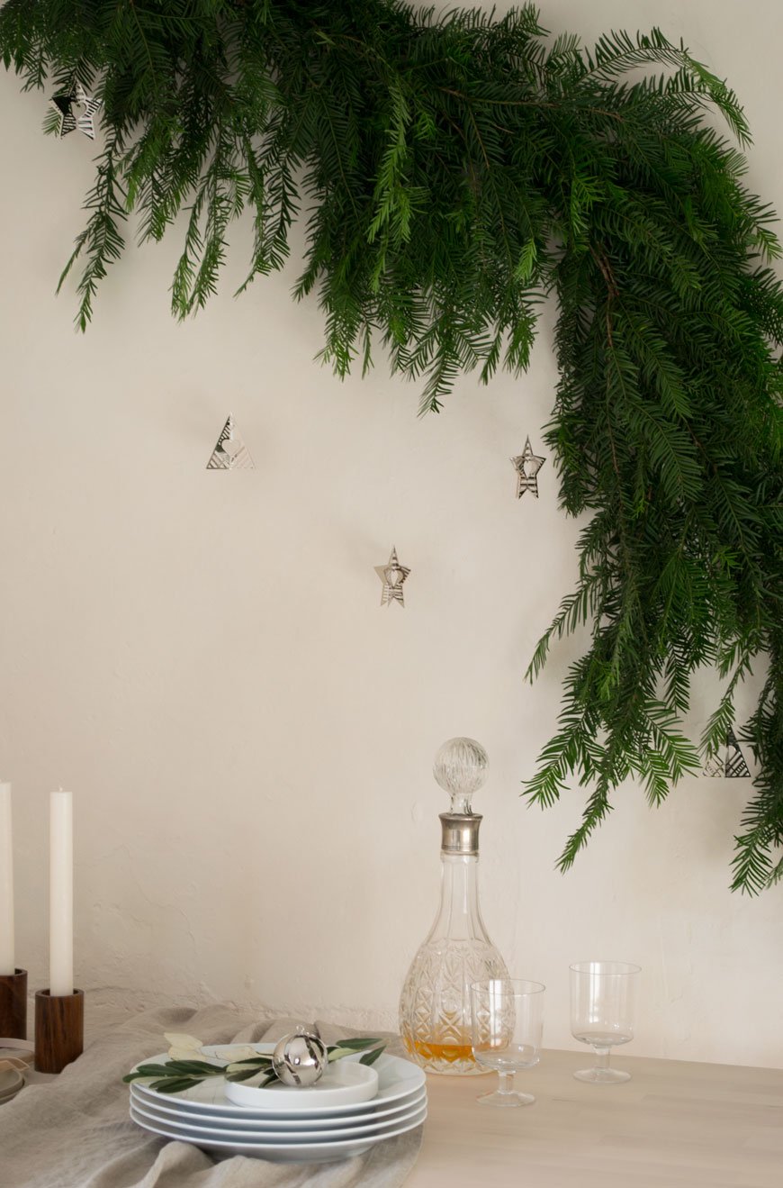 Subtle, Nordic Christmas table styling with a DIY yew tree garland. 