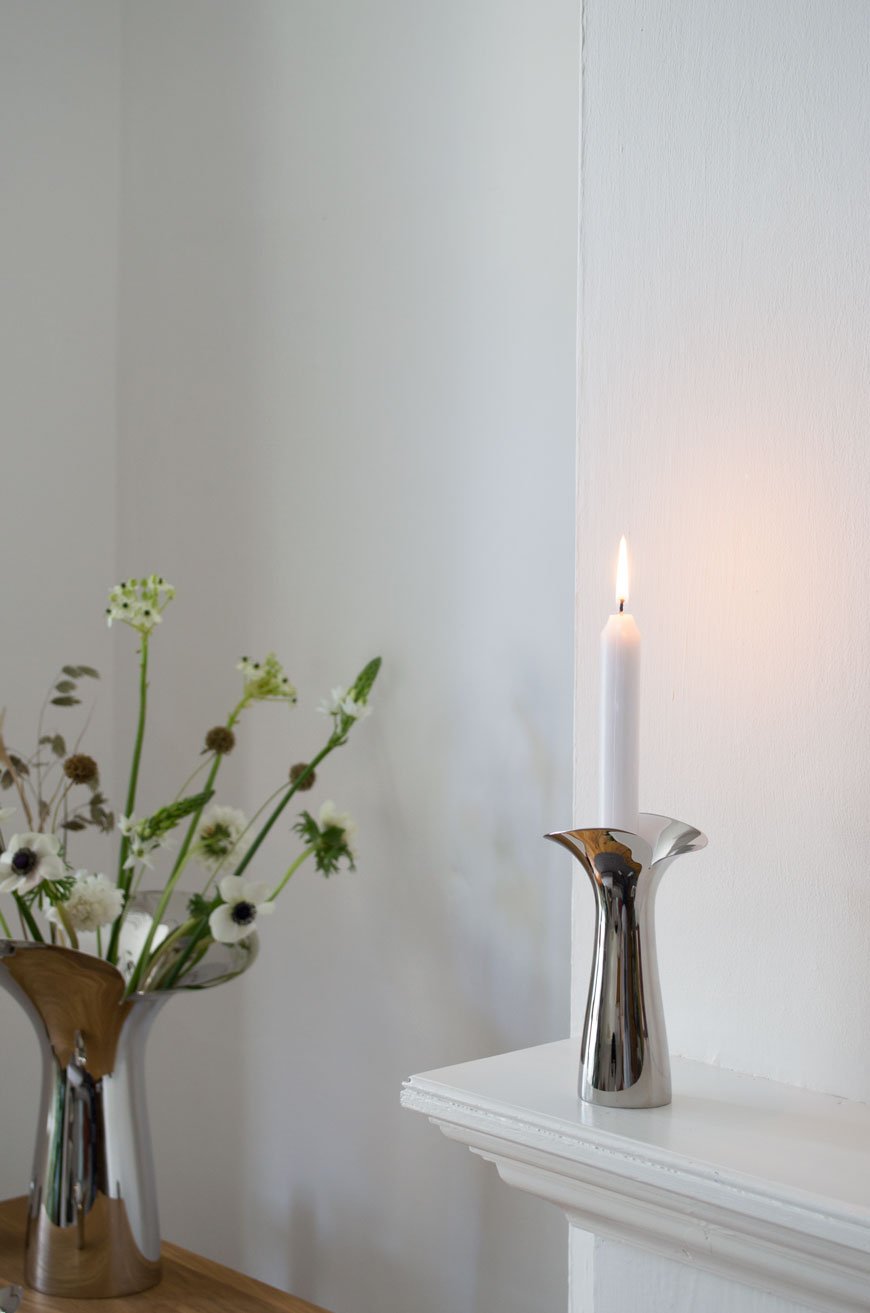 A solitary white candle sits in one of Georg Jensen's new Bloom Botanica candleholders in mirror polished stainless steel 