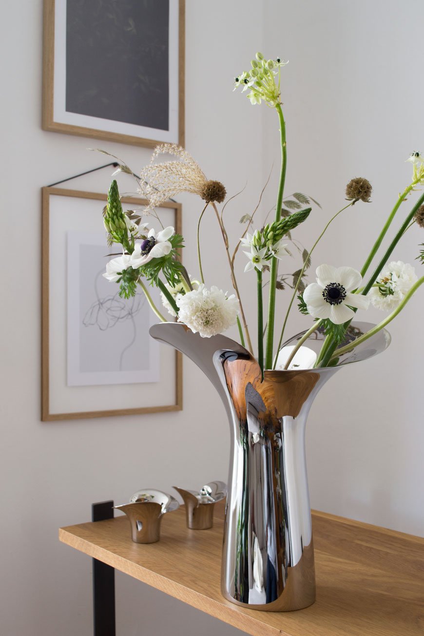Elegant, fresh white spring flowers styled with textural grasses and seed heads in the new, sculptural Bloom Botanica vase, designed by Helle Damkjær for Georg Jensen.