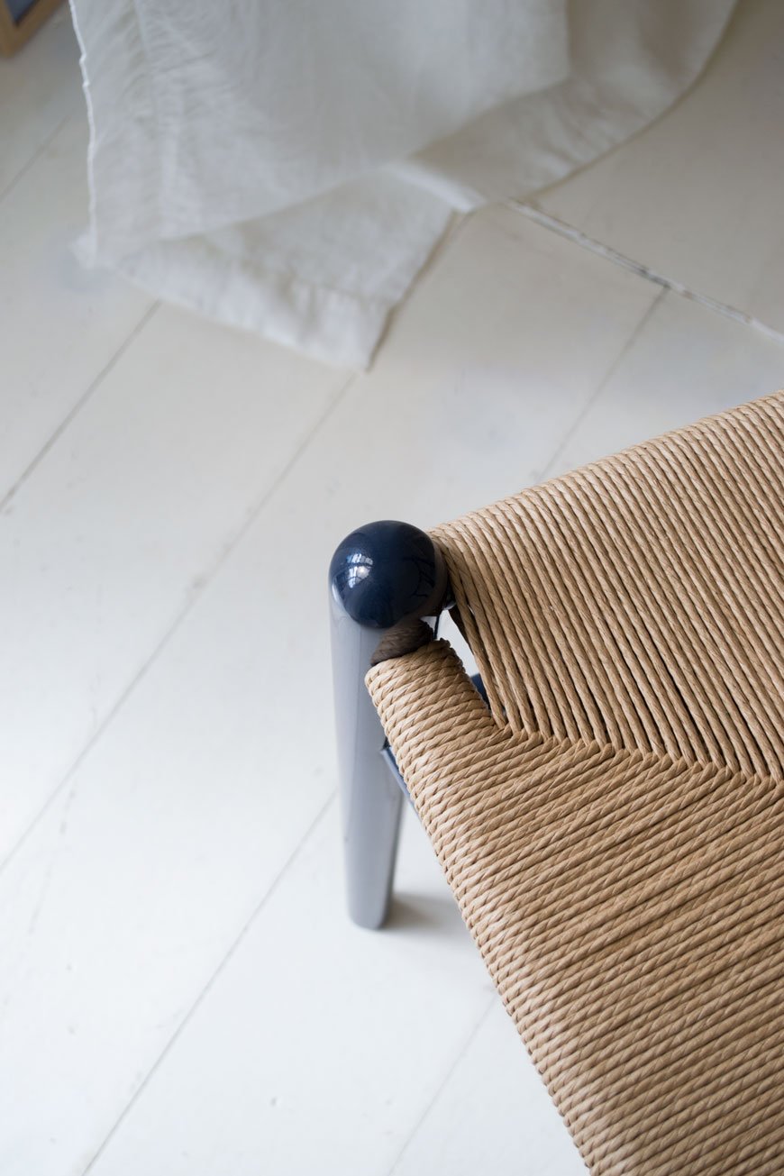 A detail shot of the woven paper cord seat of the CH24 Wishbone chair with glossy Navy blue finish. 