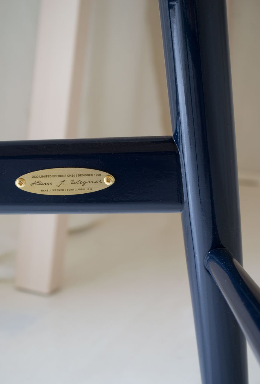 A detail of the brass plate inside the frame of the limited edition 2020 CH24 Wishbone chair in high gloss navy, designed by Hans J. Wegner.
