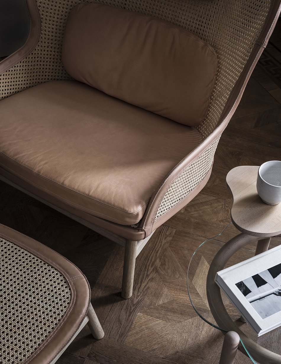 Close-up details of the Dandy rattan and leather lounge chair on parque wood floors in a Stockholm apartment. 