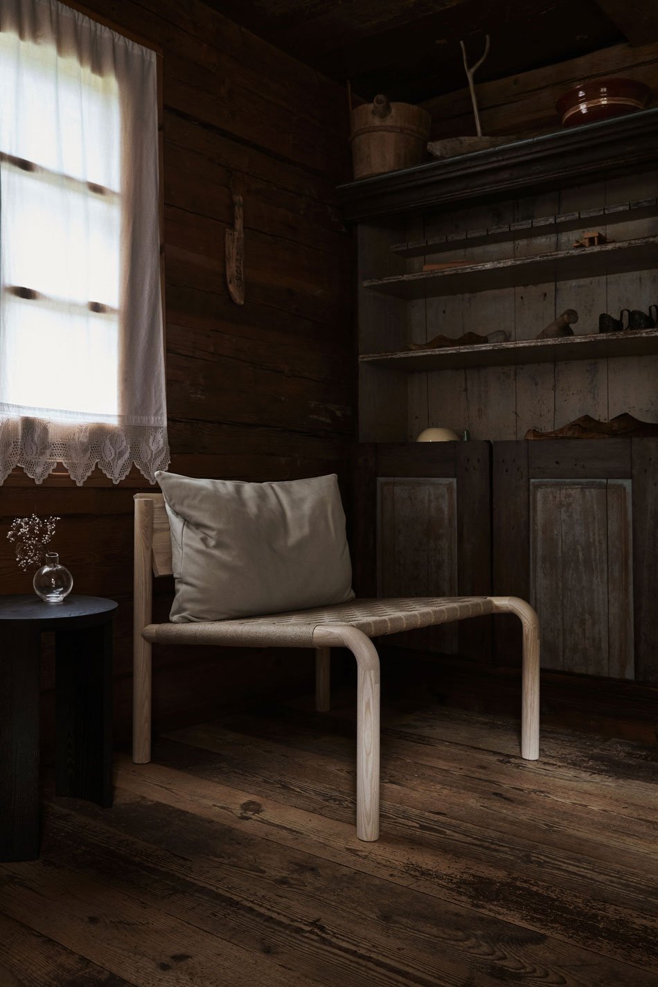 The Made By Choice Kaski linen lounge chair styled inside a traditional rustic Finnish wood cabin in the countryside. 