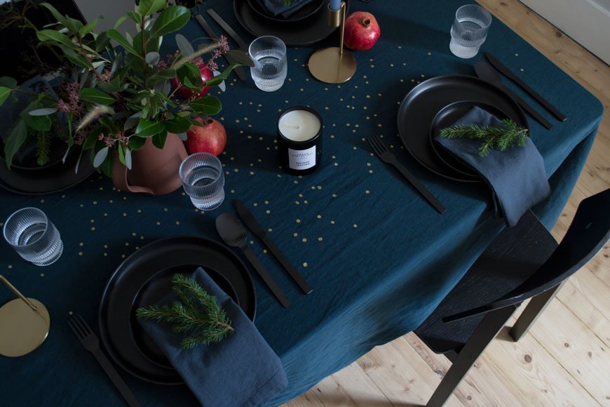 Moody and minimal Christmas table inspired by the Nordic design scene featuring deep blue table linen from La Cerise sur le gateau