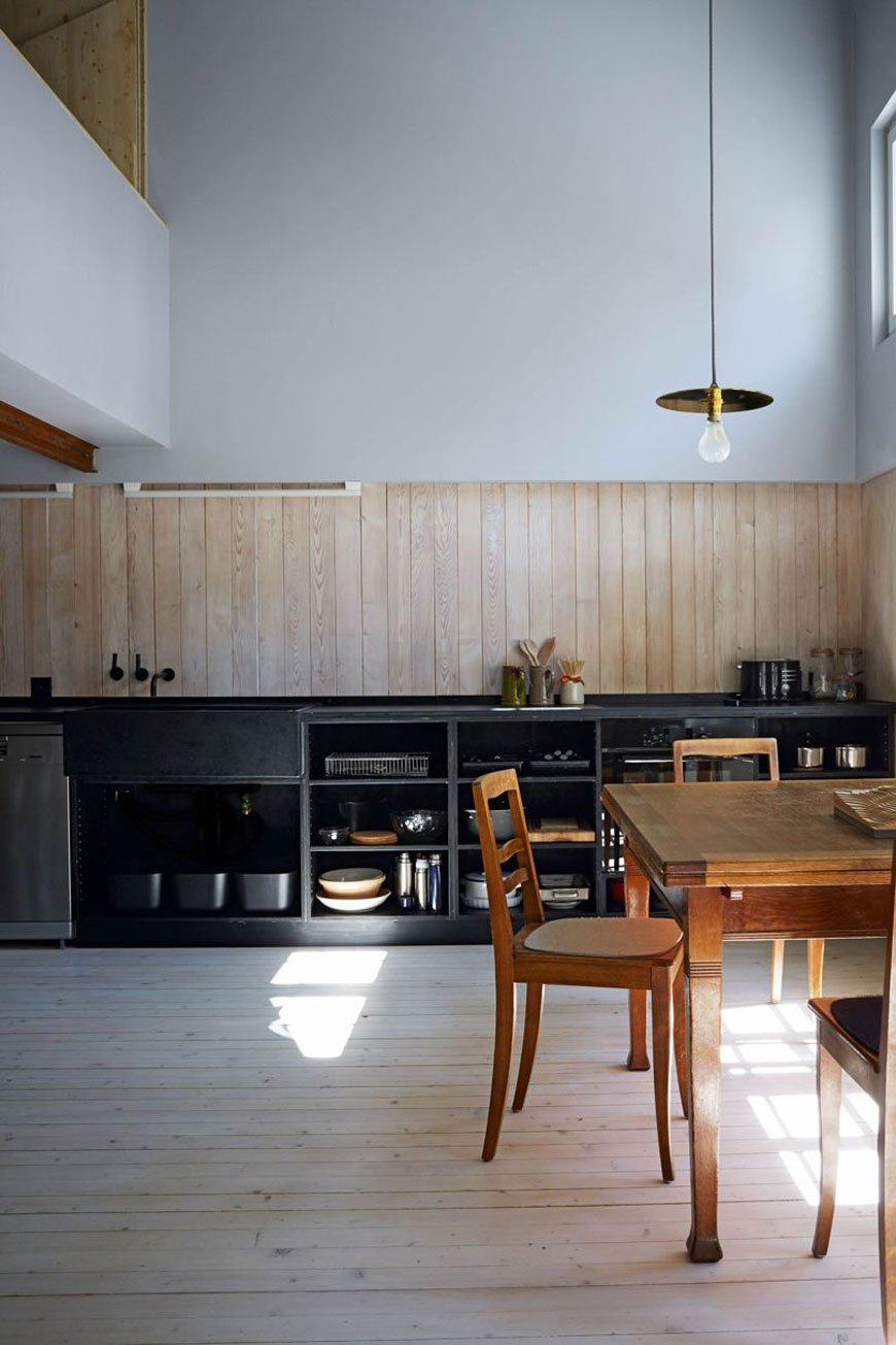 unique architectural holiday home experience, swiss chalet Halb Haus designed by Jonathan Tuckey, large open plan kitchen with mezzanine, tall ceilings