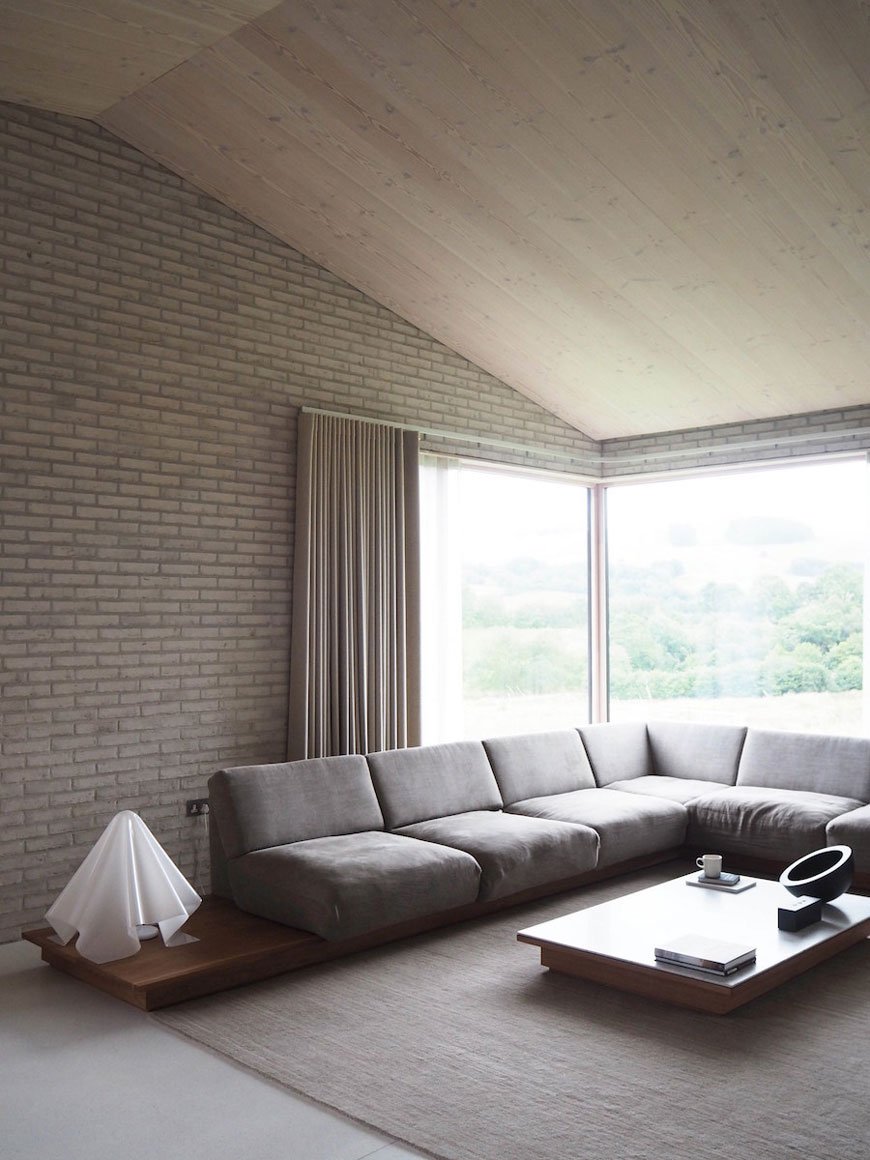 unique architectural holiday home experience, The Life House, architect John Pawson, Living Architecture, open plan living space, corner sofa, white brick walls and timber clad ceiling