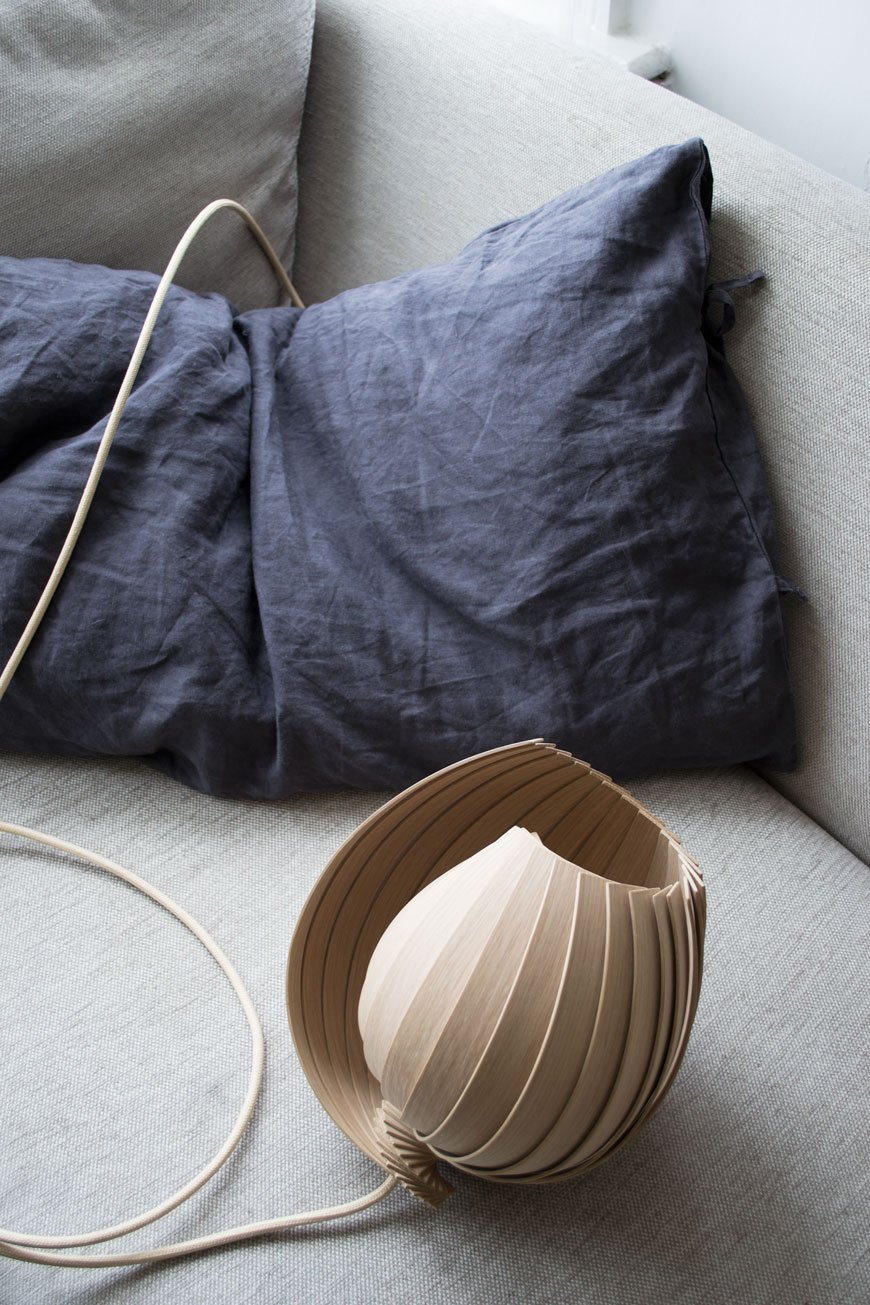 L25 Lamp designed by Kovac Family from sustainable oak, blue linen cushion on a grey sofa