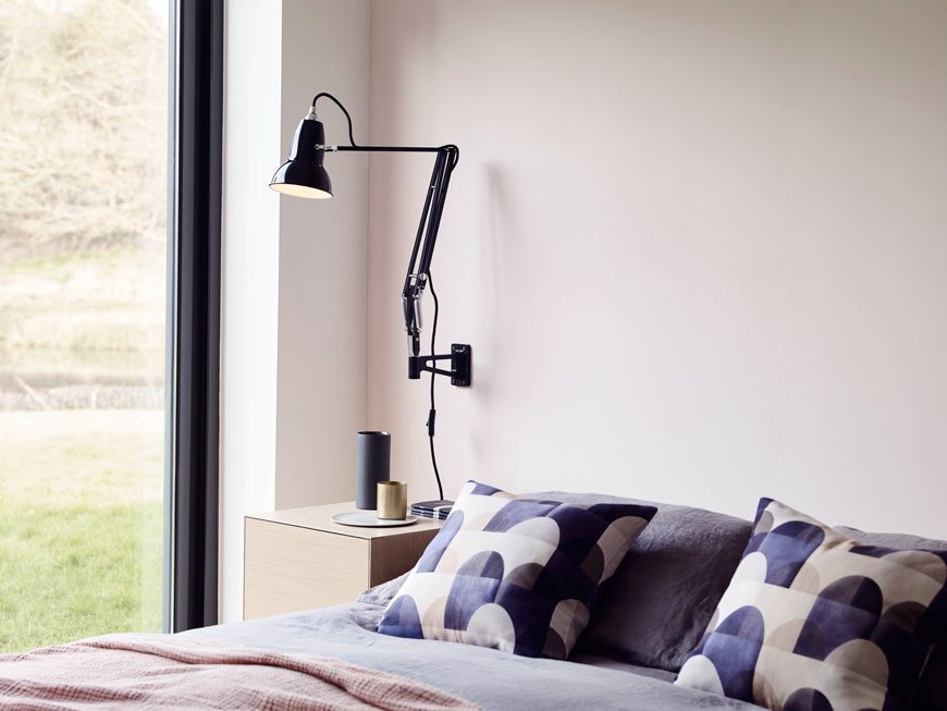 Anglepoise Original 1227 black wall light with Imogen Heath Viaduct cushions in blue in a pink bedroom