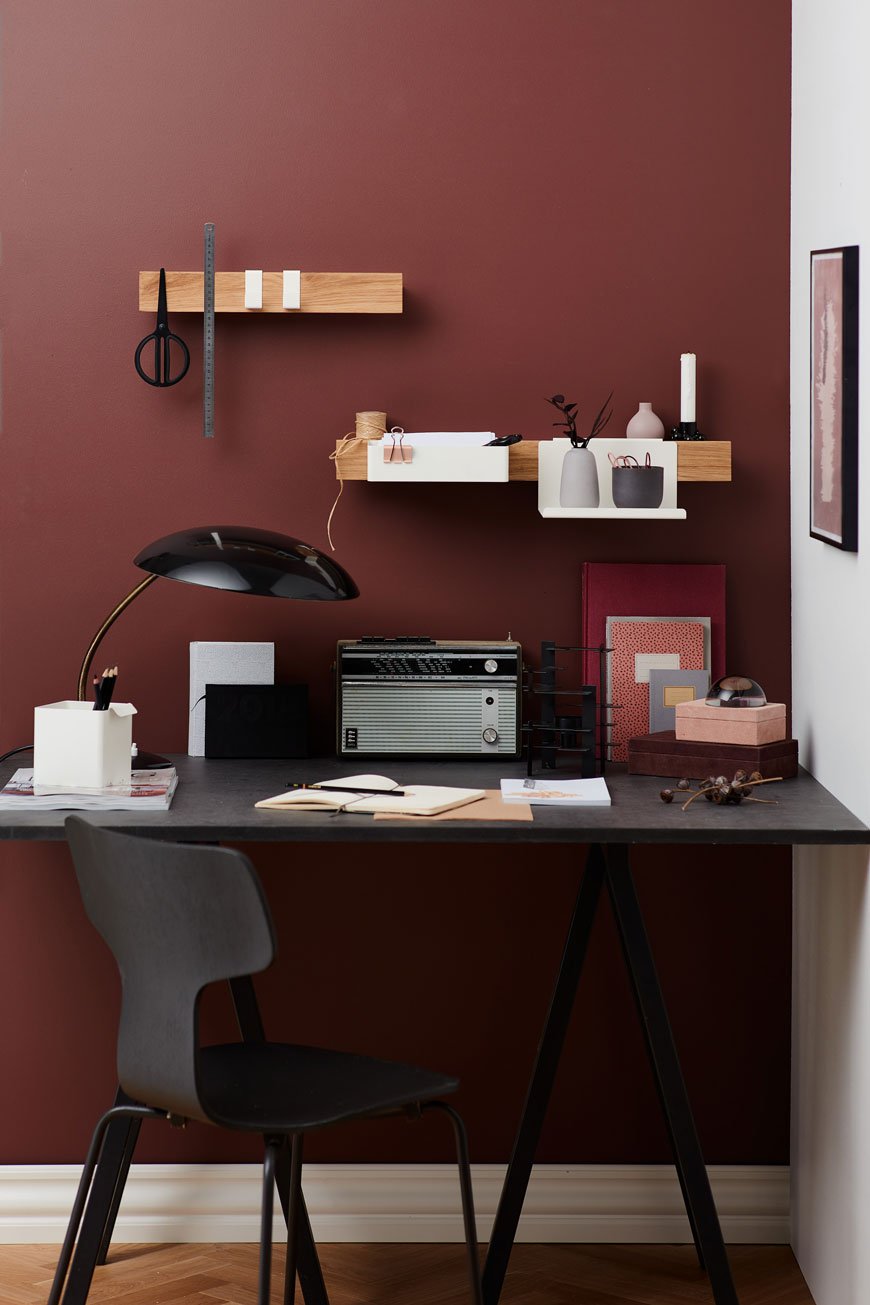A home office with red walls and a black desk feature the Flex rail by Nordic design brand Gejst.