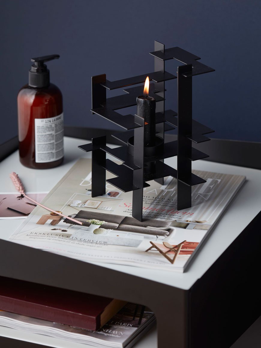 black metal candle holder styled on a cosy bedside table, designed by Nordic design brand Gejst