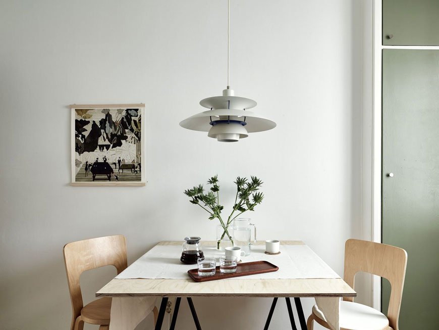 a table for two in a sweet little Gothenburg apartment with green kitchen units.