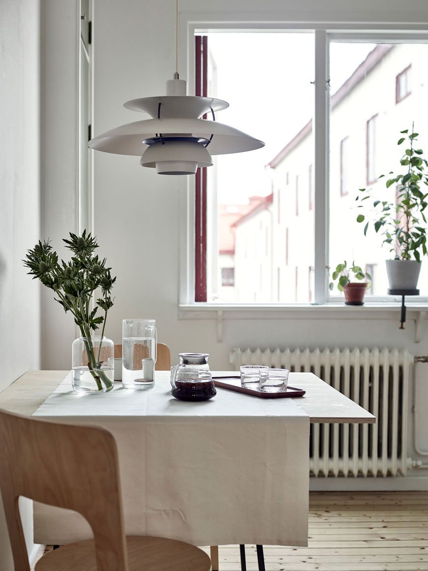 The PH 5 pendant lamp by Louis Poulsen sits over the kitchen table in a Gothenburg apartment. 