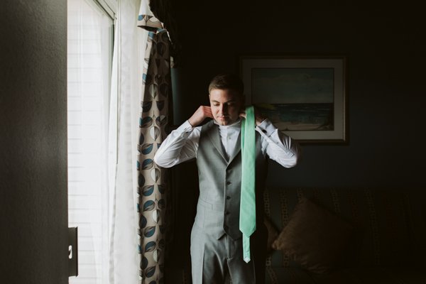 groom tying his tie 