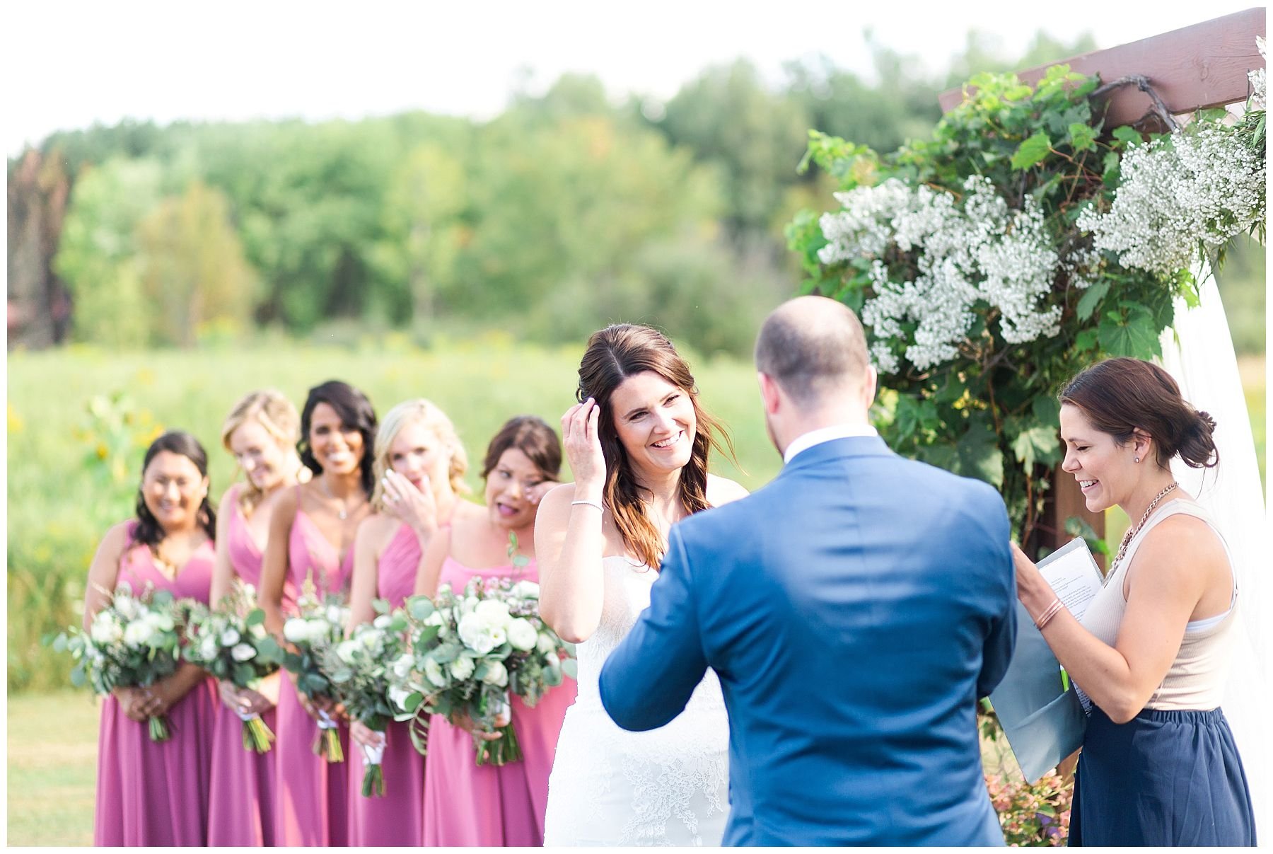 outdoor wedding ceremony under flower arch