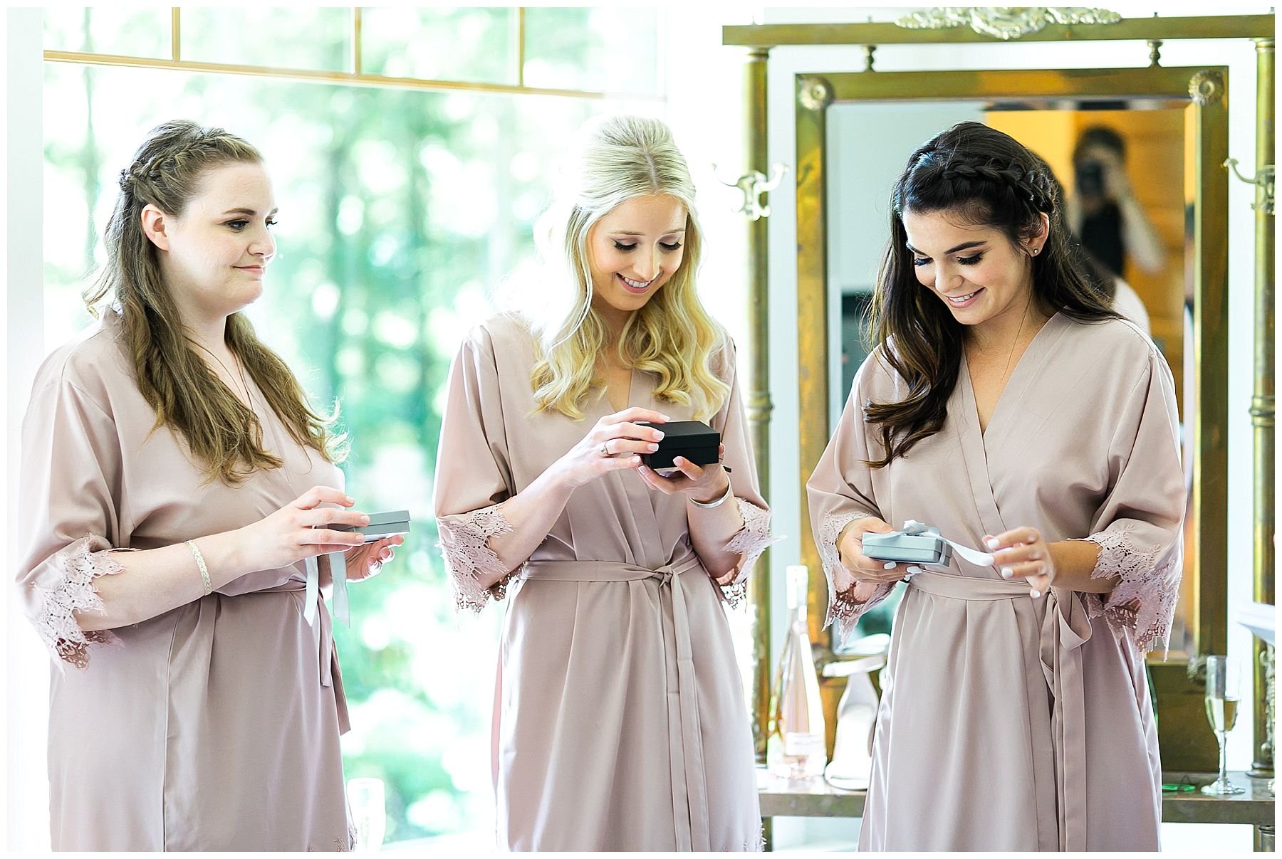 Bride giving gifts to bridesmaids in taupe robes